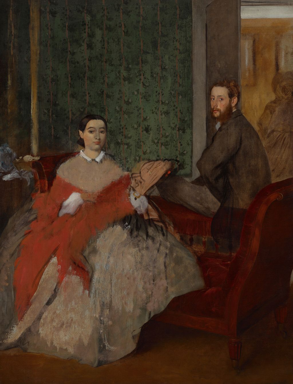 Thérèse and Edmondo Morbilli separated across a red sofa