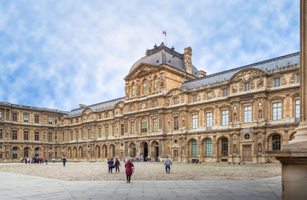 Long stone facade and courtyard of the Louvre Palace's Cour Carrée in Paris.