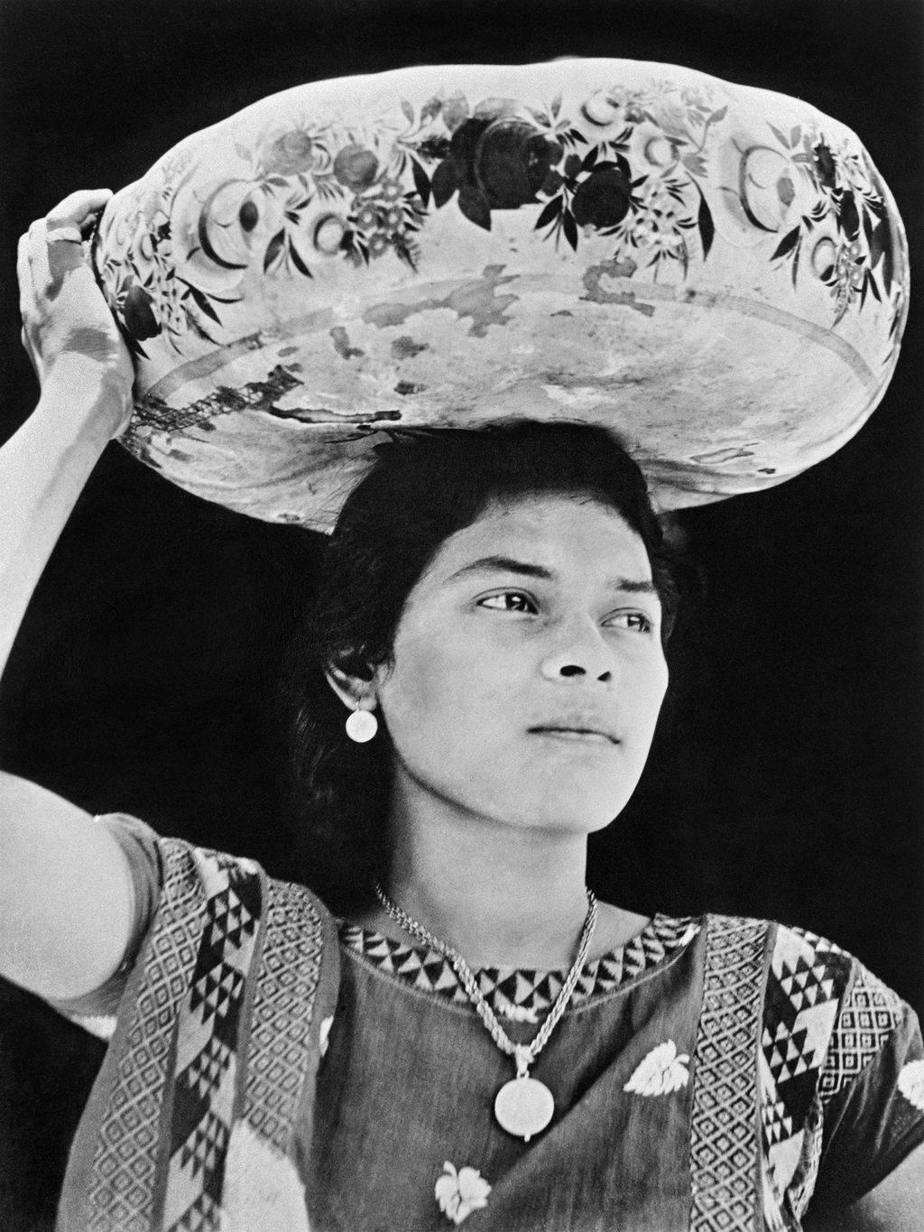 Black-and-white photograph by Tina Modotti of a woman in Tehuantepec wearing regional dress.