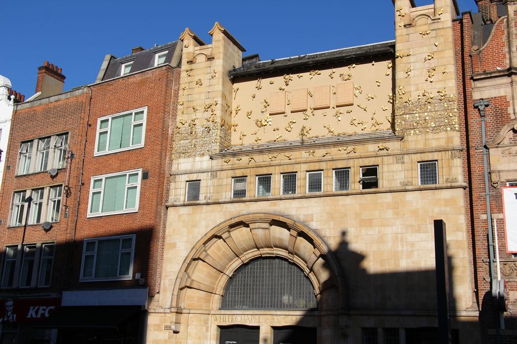 Whitechapel Gallery's street frontage, with a stone entrance and gilded relief above its windows.