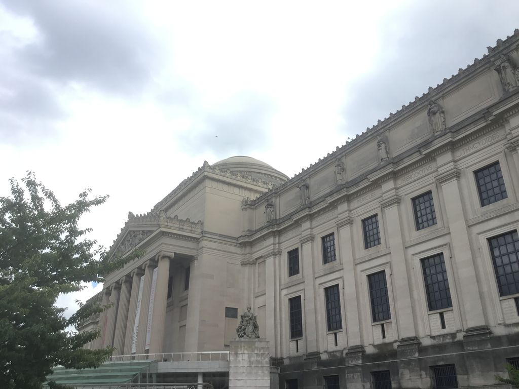 Brooklyn Museum's columned classical facade beneath an overcast sky.