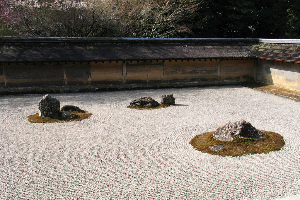 京都・龍安寺の石庭。石組、白砂、土塀と背後の樹木を一つの視界に入れる。