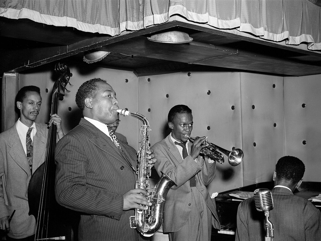 Charlie Parker playing saxophone beside bassist Tommy Potter and trumpeter Miles Davis, with Duke Jordan at the piano and Max Roach partly obscured.