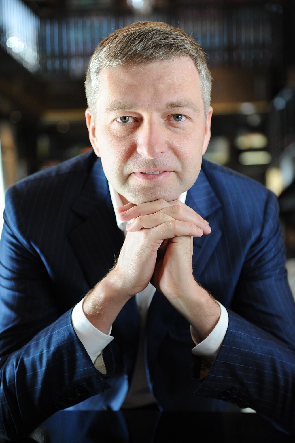 Dmitry Rybolovlev seated with his hands together in a 2012 portrait.