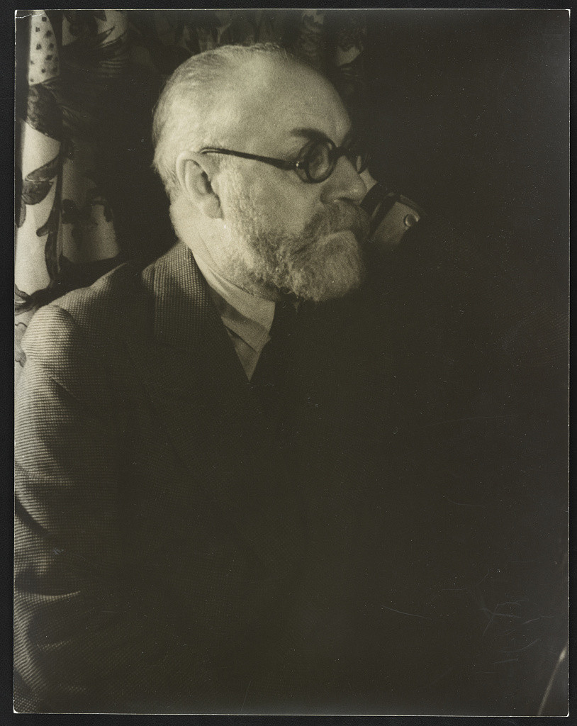 Henri Matisse in glasses and a jacket, photographed by Carl Van Vechten in 1933.