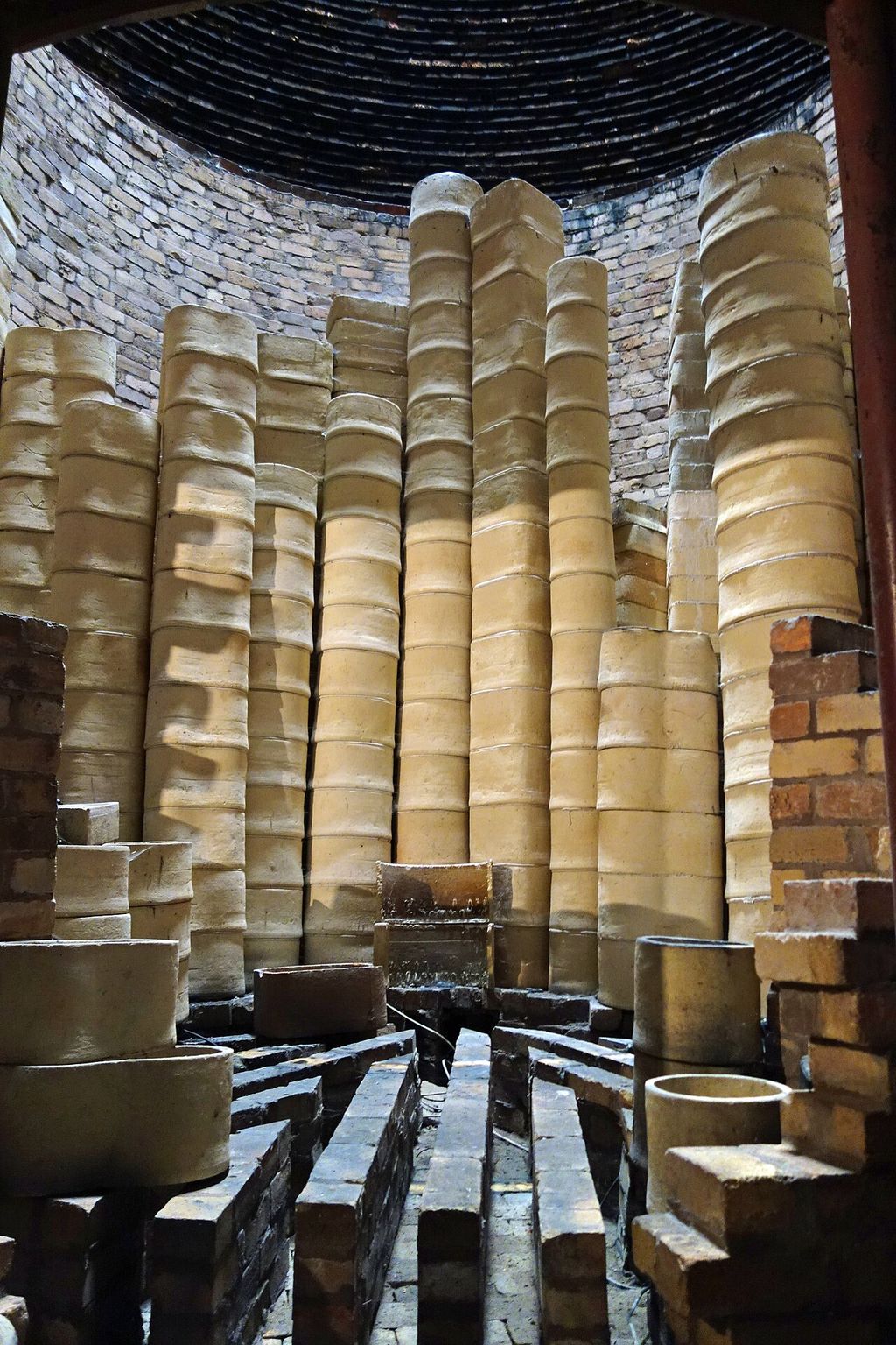 Inside a pottery kiln, where stacked wares undergo the firing stage.