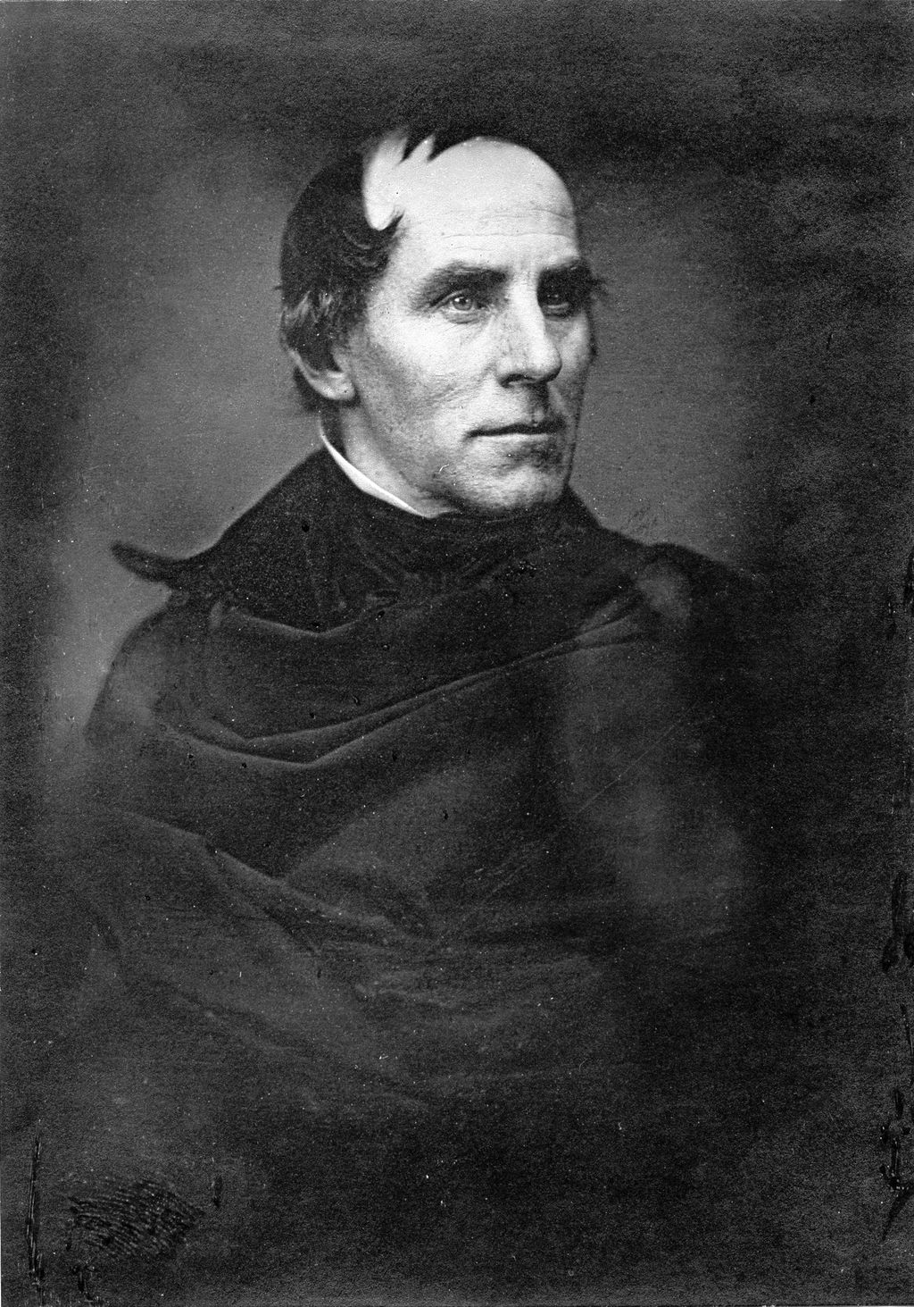 Half-length monochrome photographic portrait of Thomas Cole, seated and facing towards the viewer’s right