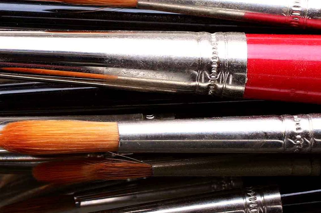 Close view of several artist brushes showing handles, ferrules and differently shaped heads.