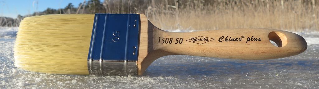 Wide professional paintbrush with a stainless-steel ferrule joining a rectangular fibre head to a wooden handle.