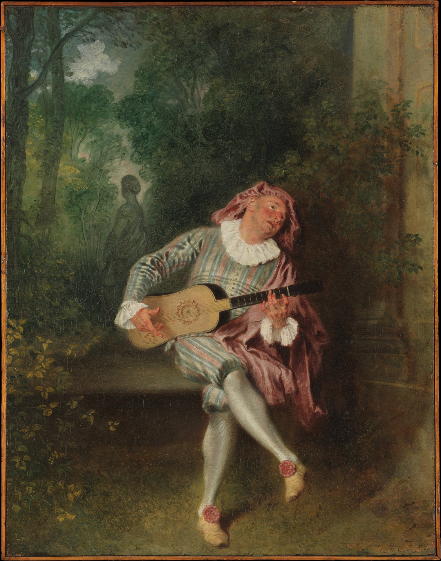 A seated costumed man plays a guitar in an overgrown garden while a female statue turns away behind him.