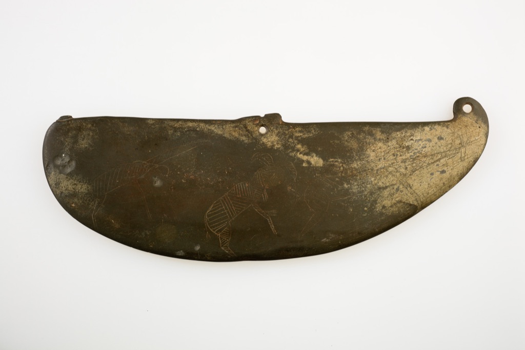 A complete dark schist palette bears shallow incised outlines of giraffes, ibex and antelope.
