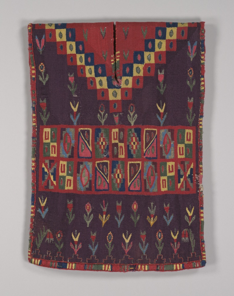 A complete Inca and Spanish miniature tabard has a rectangular garment profile filled with bands of small geometric motifs.