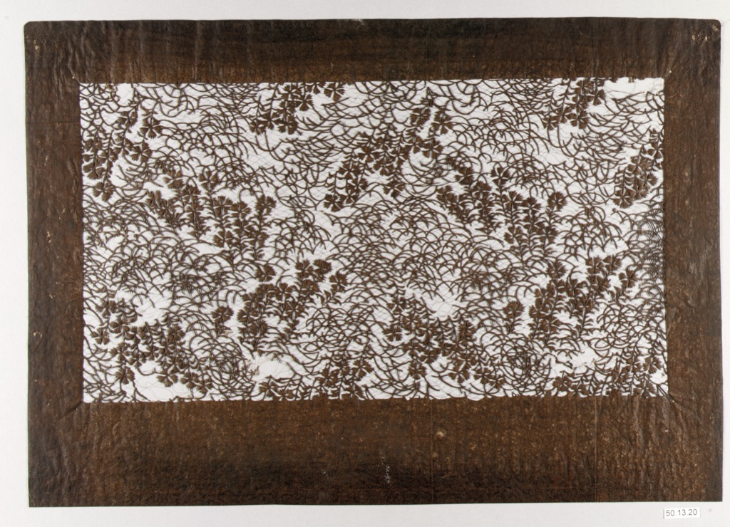 A complete nineteenth-century Japanese paper stencil contains repeated cut openings with angular and curving boundaries.
