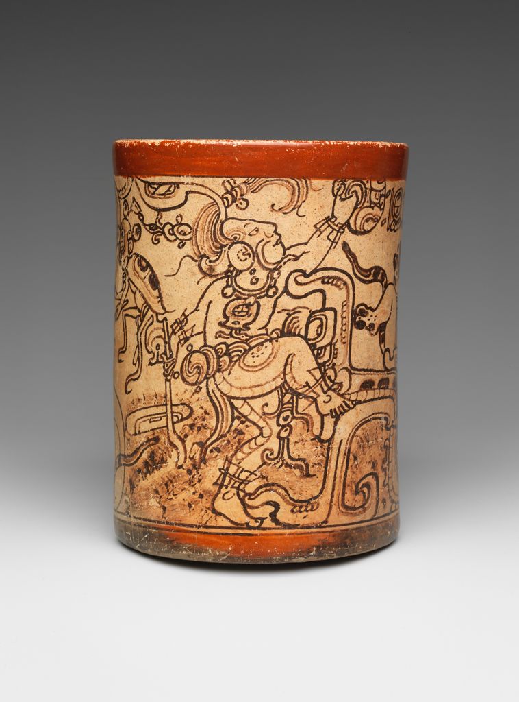 A cylindrical Maya vessel shows profile deities supernatural beings and glyphic forms painted around its pale surface.