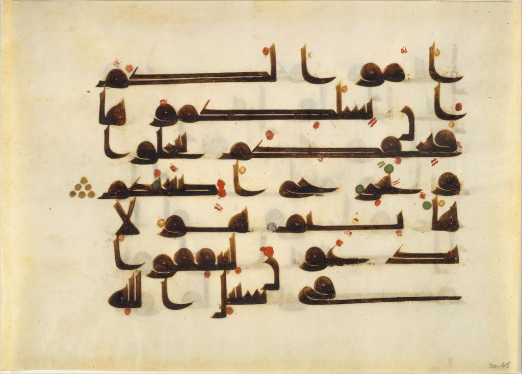 A complete parchment Qur'an folio carries broad dark lines of Arabic script with small gold and coloured details.