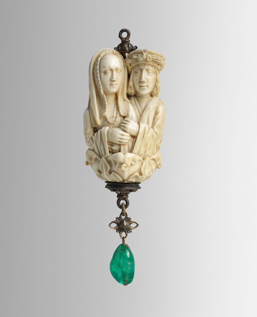 A small carved ivory rosary bead presents embracing lovers above a grinning death's head.