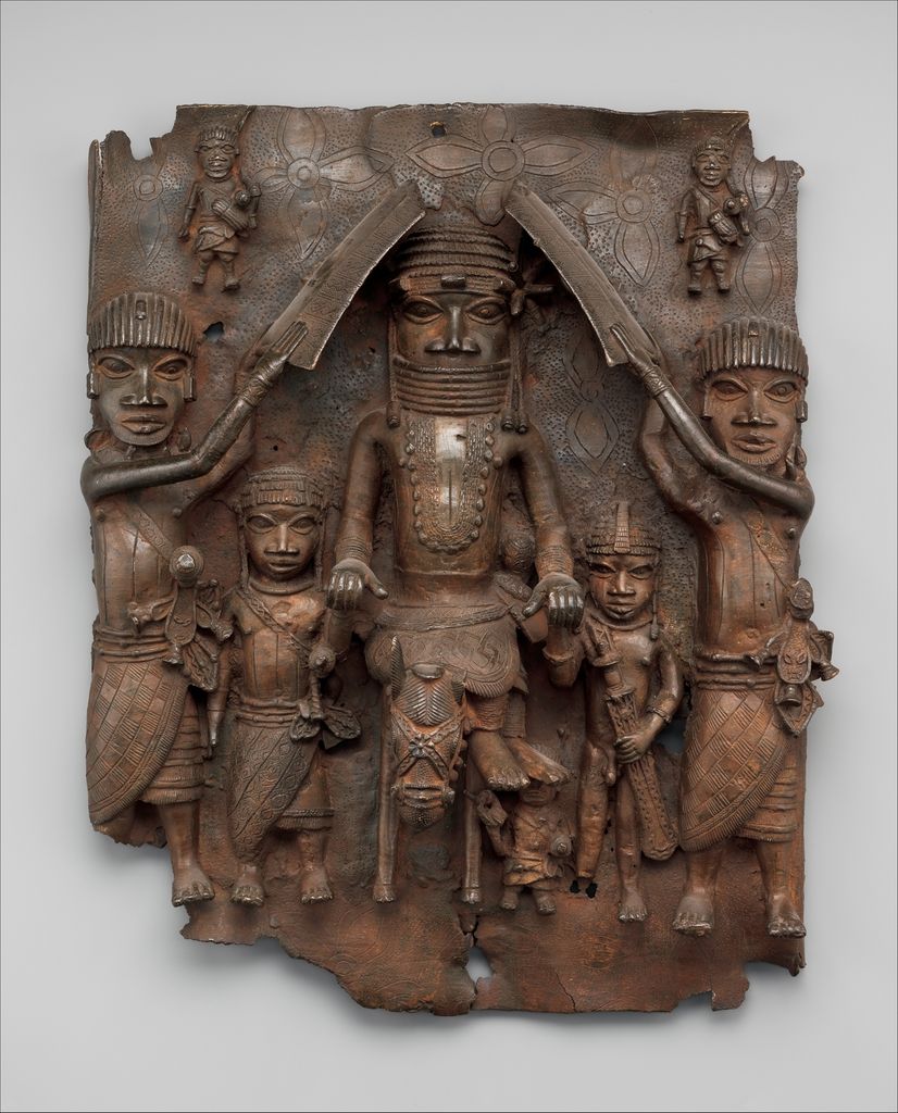 A rectangular brass plaque centres a mounted ọ́bà larger than the attendants and figures arranged around him.