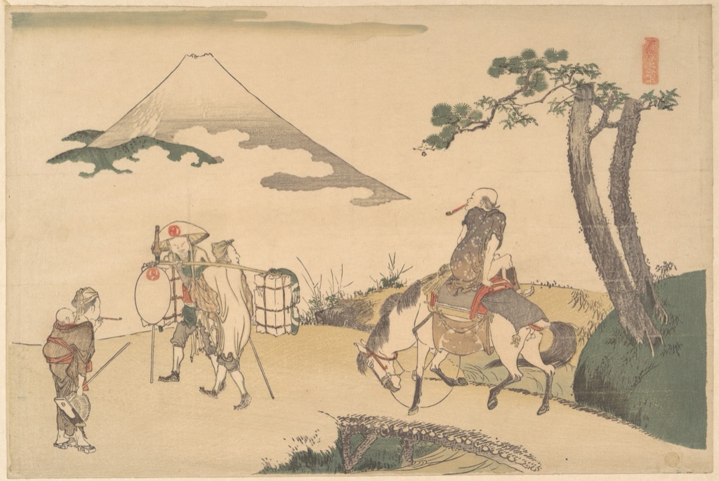 Hokusai colour woodblock print of travellers and pack animals beneath Mount Fuji