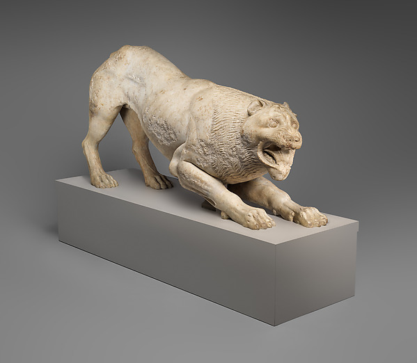 Greek marble lion standing with its head turned sharply to one side.