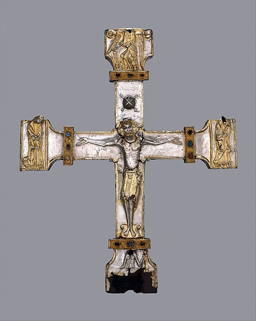 Silver processional cross with a crucified figure, gems and repoussé ornament over a wood core.