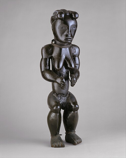 Dark wood Okak-Fang reliquary guardian with copper-alloy eyes and an oiled surface.
