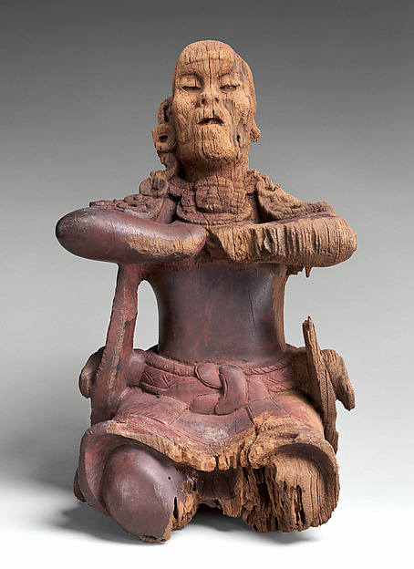 Small Maya bocote wood figure leaning forward beneath the support for a mirror.
