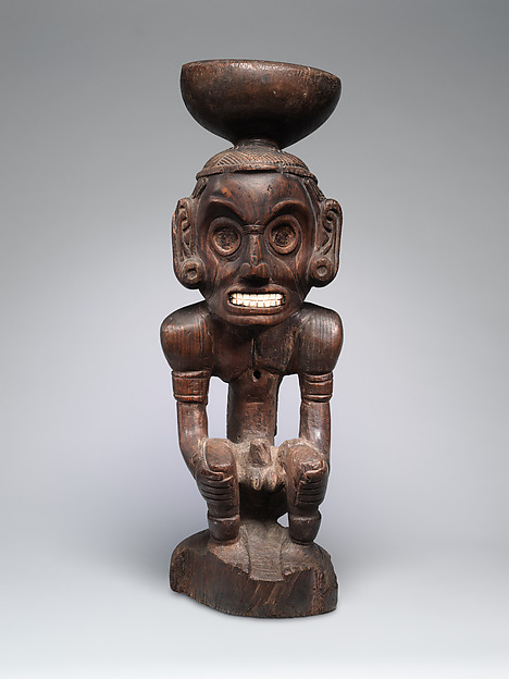 Taíno guaiacum wood stand shaped as a crouching spirit figure with shell inlay.